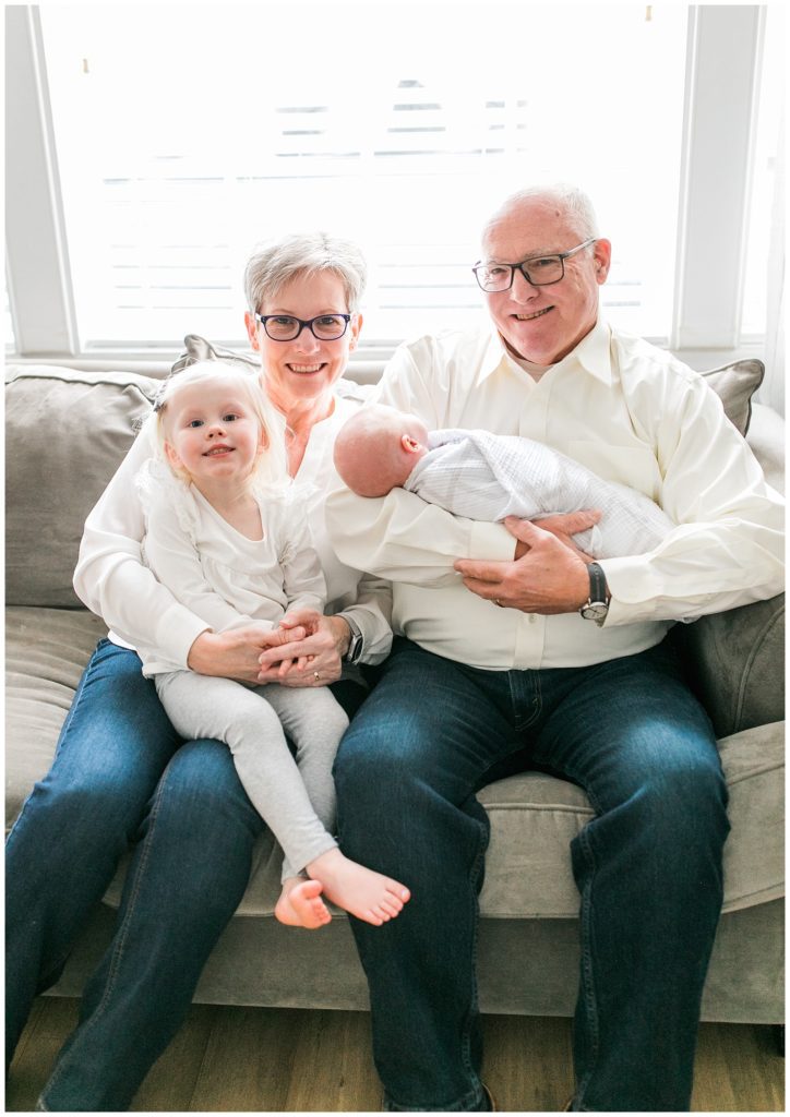 Grandparents with grandchildren at newborn session on a couch
