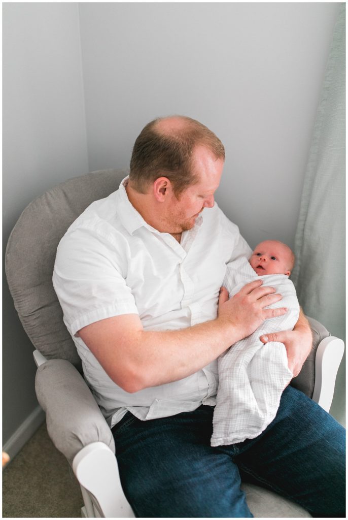 dad with newborn son in nursery