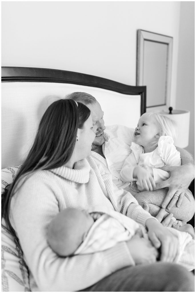 black and white family snuggling newborn photo session