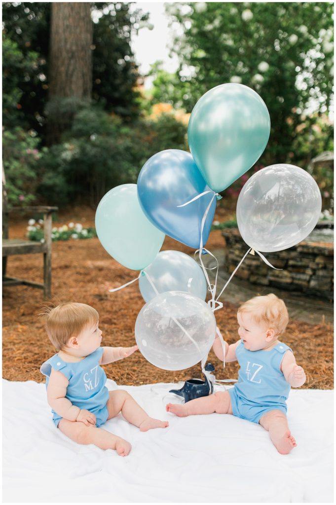 twin boys playing with blue balloons photo shoot