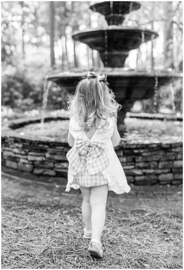 black and white little girl in front of fountain