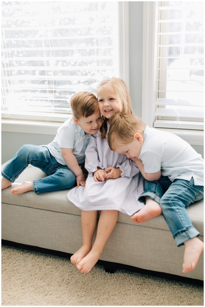 Siblings snuggle in home photo shoot