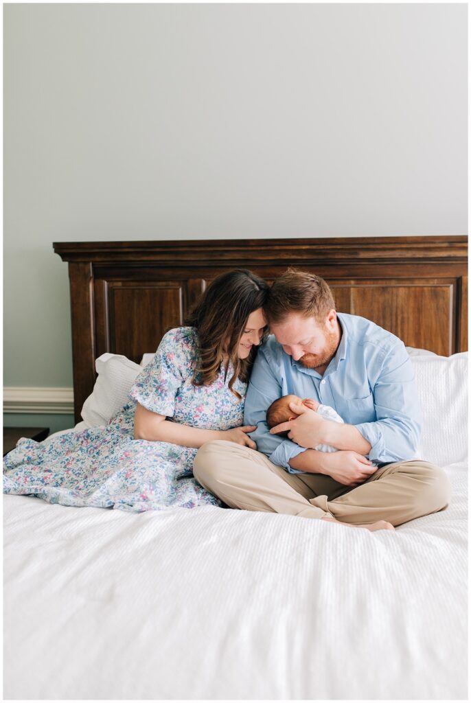Raleigh newborn lifestyle photography parents with baby boy in bed