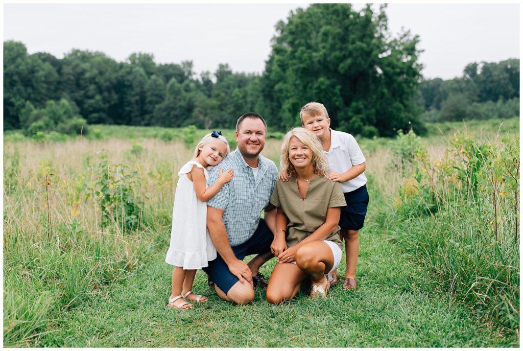 Family kneeling in a field photoshoot